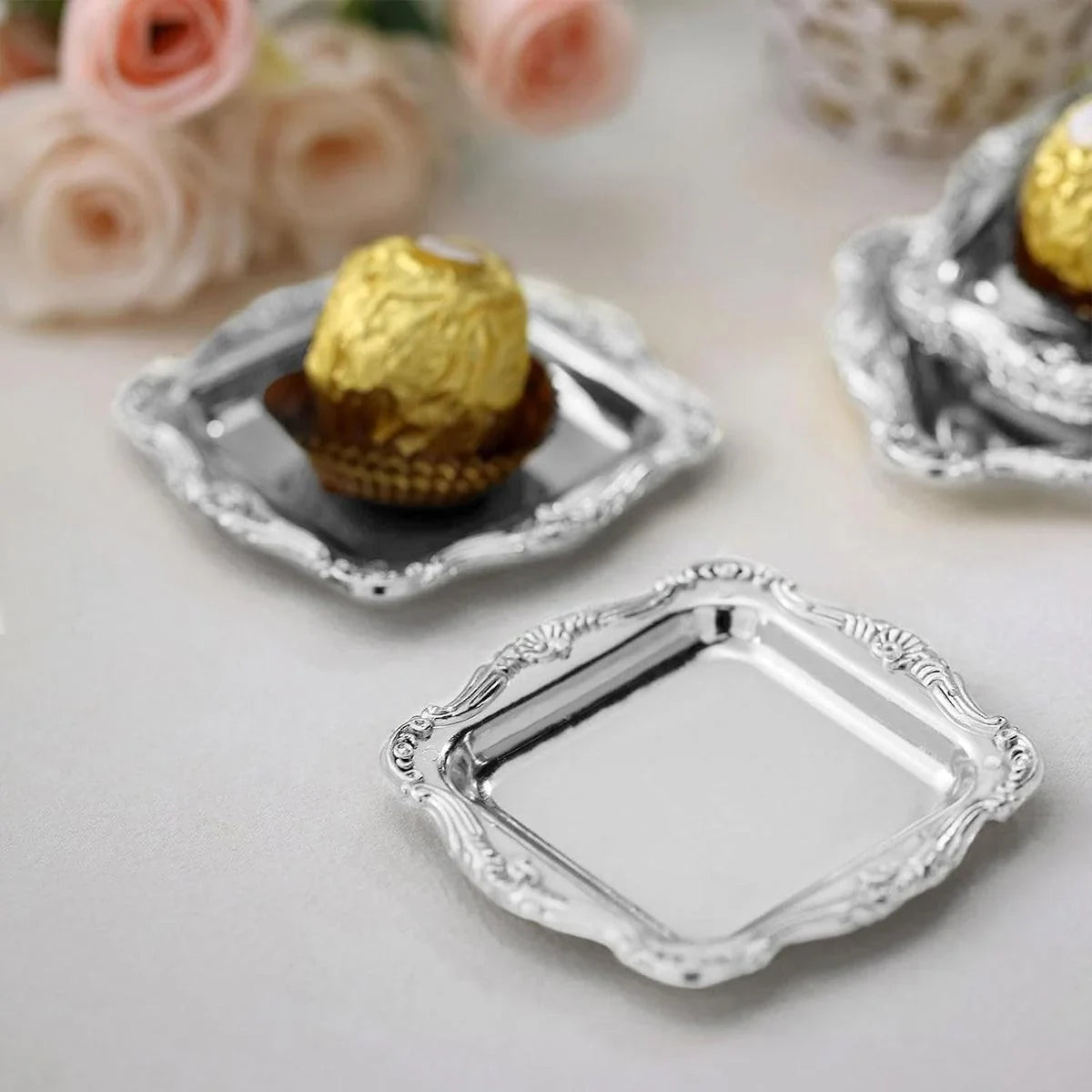 Add elegance to your table with vintage-style square plastic plates. Perfect for serving desserts, chocolates, and snacks. Available in gold and silver. Set of 12.