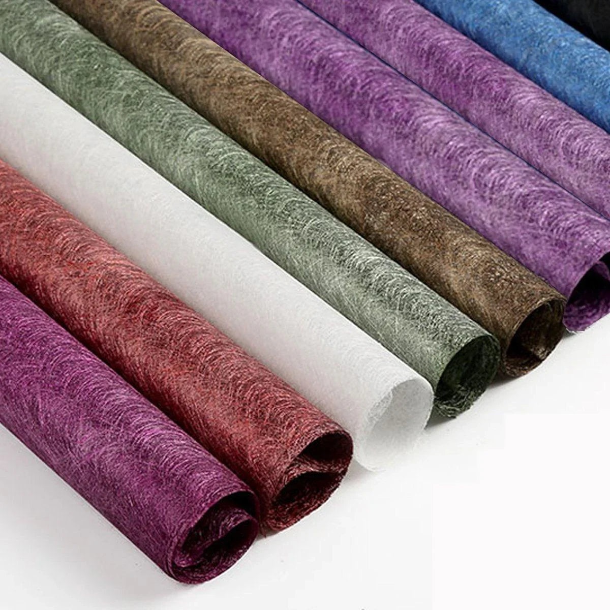 A selection of fabric sheets in various colors, including pink, white, brown, and blue.