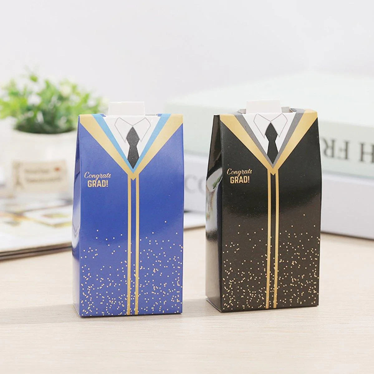 Two large candy boxes designed like graduation robes in blue and black, with gold accents.