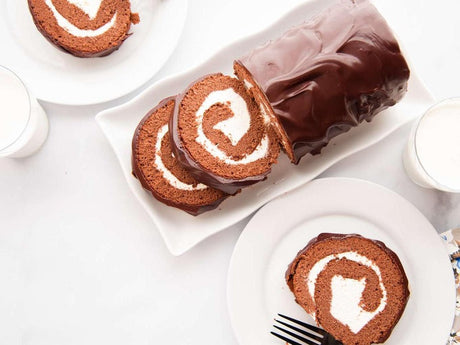 slices of a chocolate Swiss roll with a creamy filling, coated in a glossy layer of chocolate