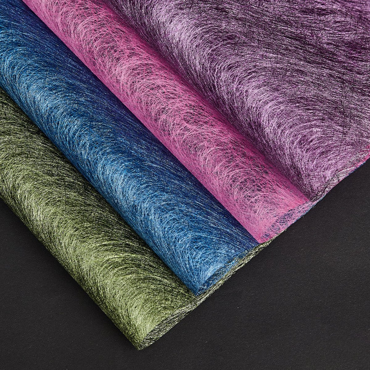 A selection of fabric sheets in various colors, including pink, white, brown, and blue.
