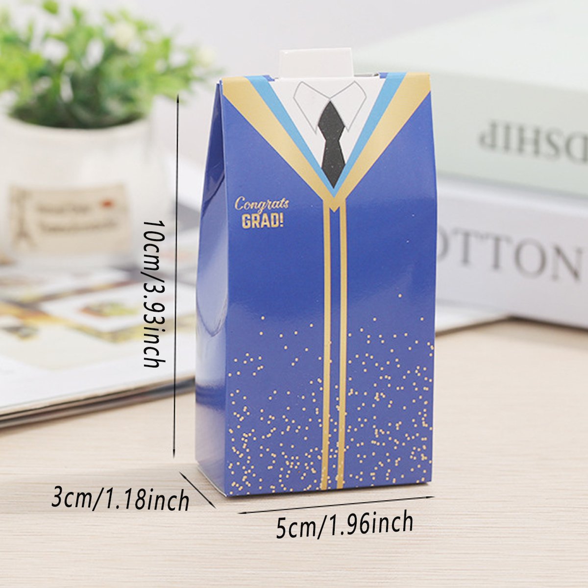 A single blue and black candy box with a graduation gown and tie design shown from the side.
