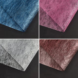 A selection of fabric sheets in various colors, including pink, white, brown, and blue.
