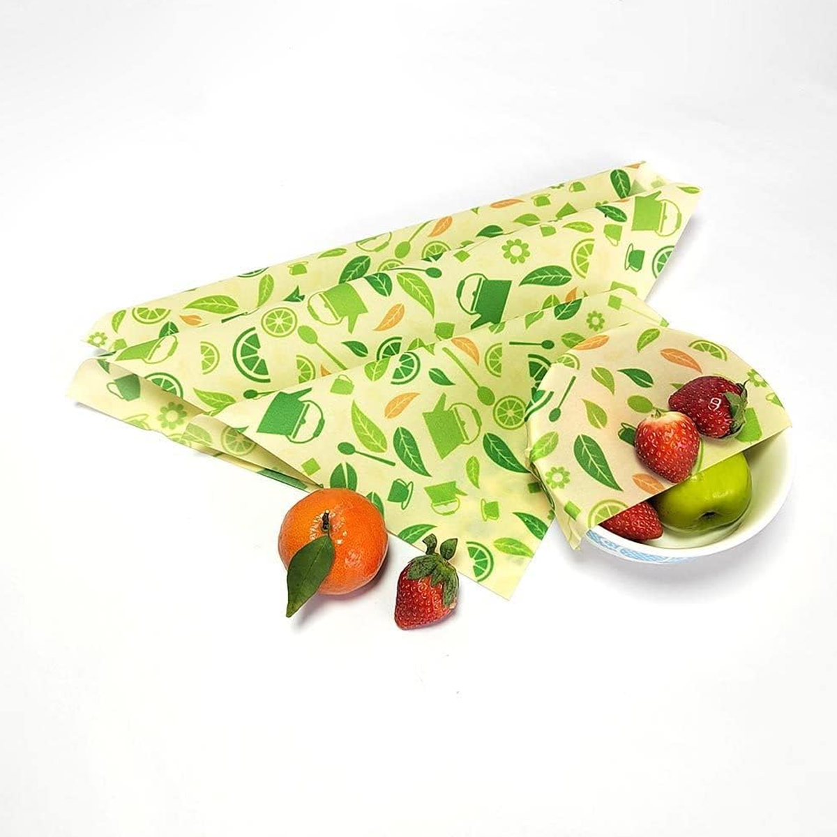 Reusable beeswax food wrap roll with green and orange fruit and leaf prints